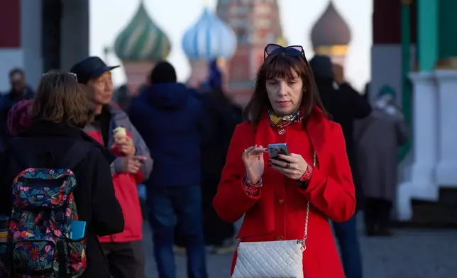 資料圖片：2026年3月11日，一名女子手持智能手機離開莫斯科紅場。(美聯社圖片/Alexander Zemlianichenko) AP圖片