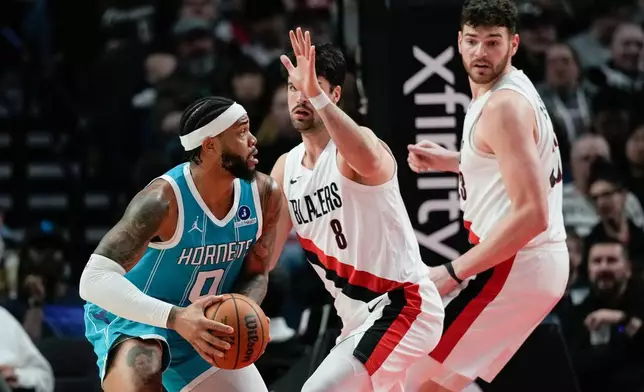 夏洛特黃蜂前鋒布里捷斯（Miles Bridges，0號）試圖繞過波特蘭拓荒者前鋒阿維迪查（Deni Avdija，8號）及中鋒奇寧根。AP圖片