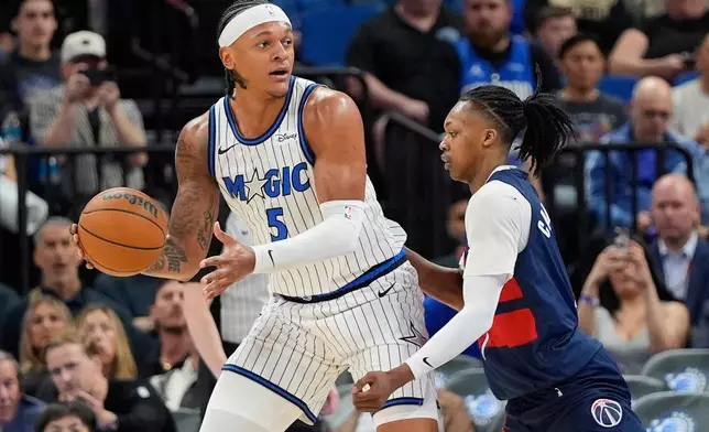 奧蘭多魔術（Orlando Magic）前鋒保羅班哲羅（Paolo Banchero，5號）在周二（2026年3月3日）於奧蘭多舉行的NBA籃球賽上半場，在華盛頓巫師（Washington Wizards）後衛巴布卡靈頓（Bub Carrington）防守下尋找傳球機會。 (美聯社圖片/John Raoux) AP圖片