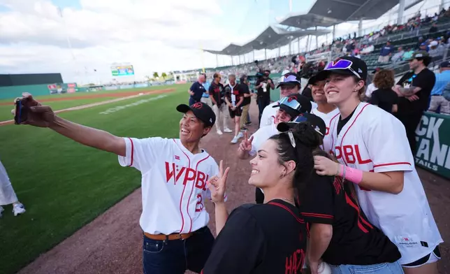 2026年3月19日周四，在佛羅里達州邁爾斯堡（Fort Myers），波士頓紅襪隊（Boston Red Sox）與明尼蘇達雙城隊（Minnesota Twins）的春季訓練賽前，包括佐藤綾美（Ayami Sato，左）在內的女子職業棒球聯盟（Women's Pro Baseball League）球員在球場上合影。(美聯社圖片/Rebecca Blackwell) AP圖片