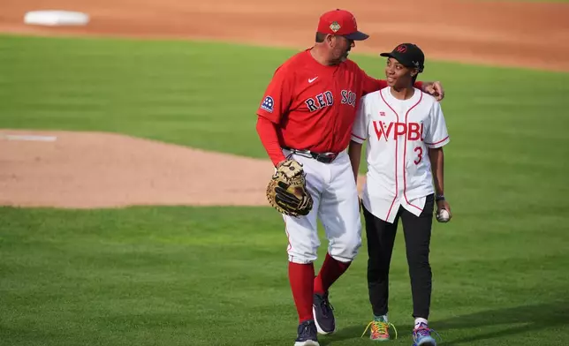 2026年3月19日周四，在佛羅里達州邁爾斯堡（Fort Myers），波士頓紅襪隊（Boston Red Sox）與明尼蘇達雙城隊（Minnesota Twins）的春季訓練賽開始前，女子職業棒球聯盟（Women's Pro Baseball League）的莫妮戴維斯（Mo'ne Davis，右）與紅襪隊比賽策劃及失分預防教練積遜華利泰克（Jason Varitek，左）在開球儀式後合照。(美聯社圖片/Rebecca Blackwell) AP圖片