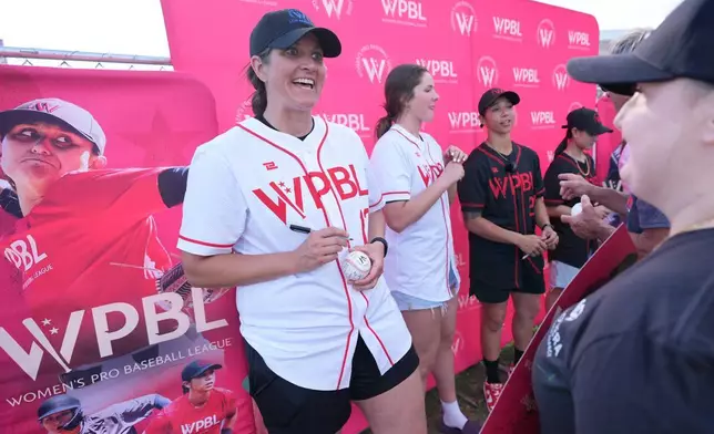 2026年3月19日周四，在佛羅里達州邁爾斯堡（Fort Myers），波士頓紅襪隊（Boston Red Sox）與明尼蘇達雙城隊（Minnesota Twins）的春季訓練賽前，梅姬梅德林格（Meggie Meidlinger，左）在女子職業棒球聯盟（Women's Pro Baseball League）的球迷嘉年華活動中為球迷簽名並交談。(美聯社圖片/Rebecca Blackwell) AP圖片