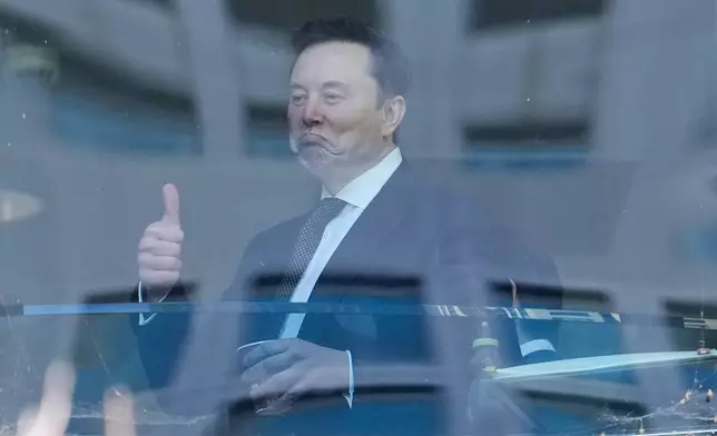 2026年4月29日周三，馬斯克（Elon Musk）（左）在加州奧克蘭（Oakland, Calif.）的美國聯邦地區法院（U.S. District Court）內走過走廊時做出手勢。（美聯社圖片/Godofredo A. Vásquez） AP圖片