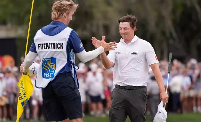 英格蘭球手費茲柏德（Matt Fitzpatrick）（右）在2026年4月19日（周日）美國南卡羅來納州希爾頓黑德島（Hilton Head, S.C.）贏得RBC傳承賽（RBC Heritage）高爾夫錦標賽後，與球僮Daniel Parratt一同慶祝。(美聯社圖片/Mike Stewart) AP圖片