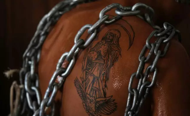 一名懺悔者在2026年4月3日周五墨西哥阿特利斯科的聖周耶穌受難日巡遊前，其聖死（Santa Muerte）紋身披上鎖鏈。(美聯社圖片/Fernando Llano) AP圖片