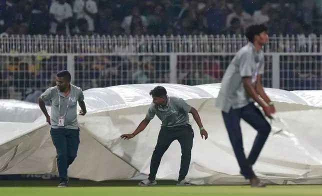 地勤人員將雨布拉到球場上，當時印度加爾各答正下雨，印度超級板球聯賽（Indian Premier League）加爾各答騎士隊（Kolkata Knight Riders）對陣旁遮普王者隊（Punjab Kings）的板球賽事於2026年4月6日周一舉行。(美聯社圖片/Bikas Das) AP圖片