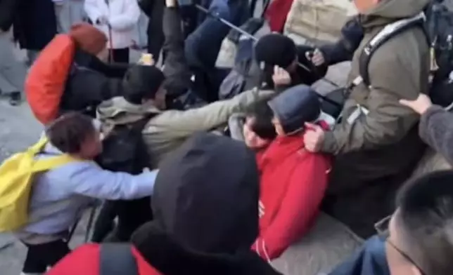 泰山遊客為爭奪觀賞日出位爆肢體衝突，一男子遭飛踢滑落岩石邊。影片截圖