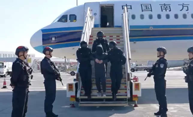 李雄被押下飛機。新華社圖片