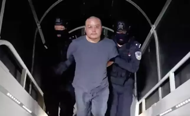 李雄被押上飛機。新華社圖片