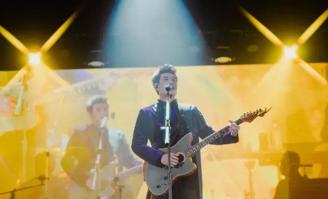 他更親自彈琴結他與觀眾互動點歌，盡顯音樂造詣。