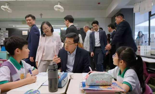 李家超到訪的學校正推行「在校課後託管服務計劃」，視察計劃運作。