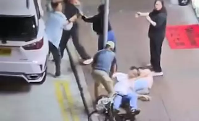 灰衫男站起來欲再上前，但被身旁兩男女勸止。網上圖片