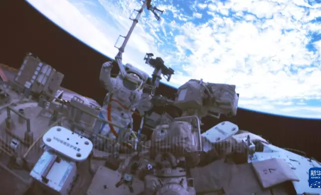 4月16日在北京航天飛行控制中心屏幕上拍攝的神舟二十一號乘組航天員武飛在艙外工作的畫面。新華社圖片