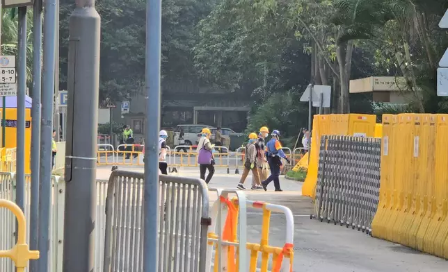 上樓居民都配備頭盔、口罩、手套等安全裝備，並由警務人員或民安隊隊員陪同上落樓及進出單位。巴士的報記者攝