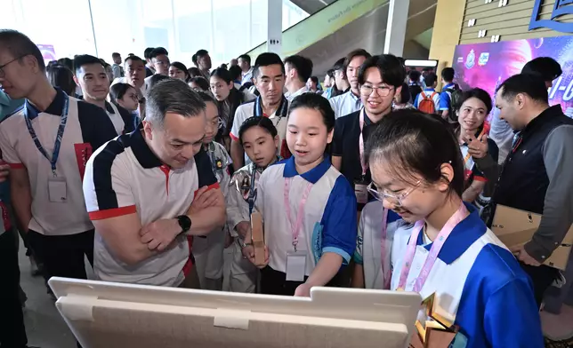 小學組冠軍得主向警務處處長周一鳴（左）介紹得獎作品。