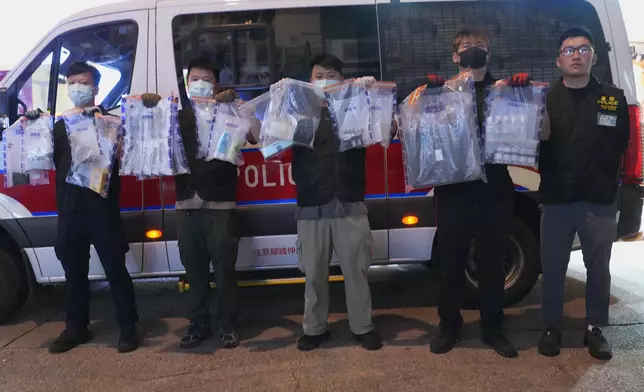 麥啟添與一眾警務人員展示證物。