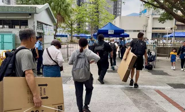 居民拿著紙箱上樓。巴士的報記者攝