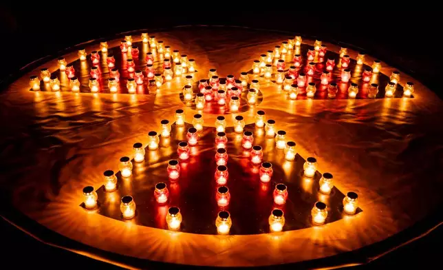 蠟燭排列成輻射危險符號，擺放在紀念碑前，悼念1986年切爾諾貝爾核災後犧牲的消防員及工人。圖為2026年4月25日周六，烏克蘭斯拉武季奇舉行核災40周年紀念活動前夕。喬爾諾貝爾 (Chornobyl) 是該市的烏克蘭語名稱。(美聯社圖片/丹巴沙科夫 Dan Bashakov) AP圖片