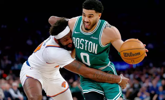 紐約人中鋒米曹羅賓遜（Mitchell Robinson）（左）在周四（2026年4月9日）於紐約舉行的一場NBA籃球賽下半場，防守波士頓塞爾特人後衛謝遜達頓。(美聯社圖片/John Munson) AP圖片