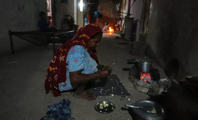在印度古吉拉特邦莫爾比，一名外來婦女在空置的瓷磚工人宿舍內，於2026年4月8日周三用煤炭準備膳食。(美聯社圖片/Ajit Solanki) AP圖片