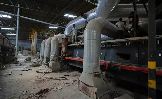 在印度古吉拉特邦莫爾比，工人們於2026年4月8日周三抵達一間關閉的瓷磚廠進行維修工作。(美聯社圖片/Ajit Solanki) AP圖片