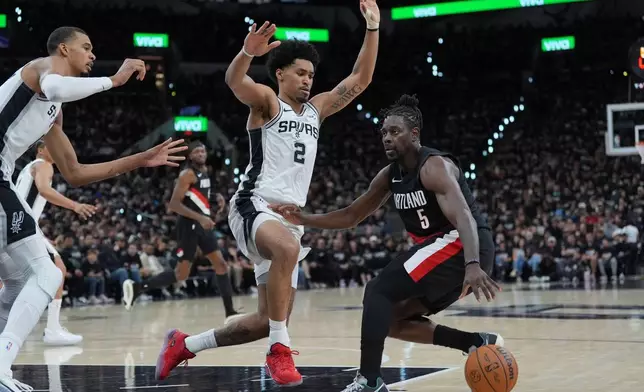 波特蘭拓荒者後衛賀列特（Jrue Holiday）（5號）在周二（2026年4月21日）於聖安東尼奧舉行的NBA季後賽首圈第二戰上半場，突破聖安東尼奧馬刺後衛哈珀（Dylan Harper）（2號）及馬刺前鋒文班亞馬（左）。(美聯社圖片/Eric Gay) AP圖片