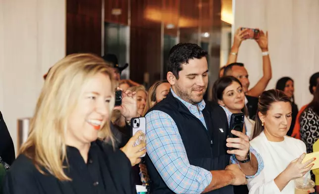 弗里斯科商會（Frisco Chamber of Commerce）主席兼行政總裁克麗絲塔爾·霍華德（Christal Howard）與人群一同觀看牛仔路（Cowboys Way）新豐盛銀行招牌的揭幕儀式。 AP圖片