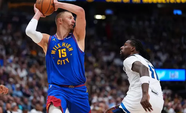 丹佛金塊（Denver Nuggets）中鋒尼高拉祖傑（Nikola Jokic）（15號）在2026年4月20日周一於丹佛舉行的NBA季後賽首圈第二戰對陣明尼蘇達木狼（Minnesota Timberwolves）的上半場期間，將球傳過木狼中鋒拿斯列特（Naz Reid）（右）。(美聯社圖片/Jack Dempsey) AP圖片