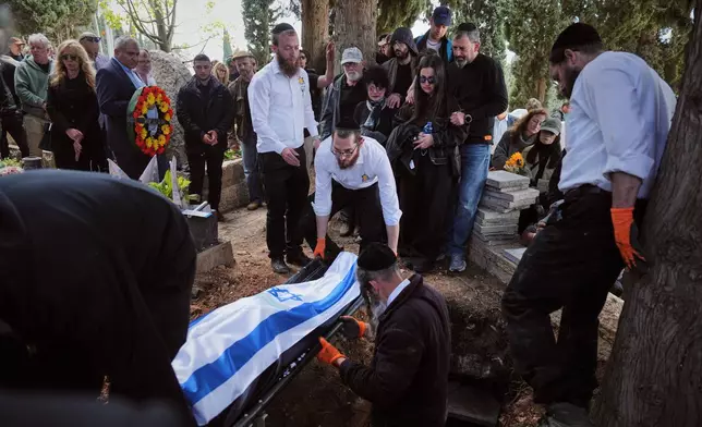 哀悼者抬著蓋有旗幟的蓋爾紹維奇家族（Gershovich family）三名成員遺體，他們因伊朗導彈襲擊建築物而喪生。攝於2026年4月7日周二，以色列海法舉行的葬禮。(美聯社圖片/Ariel Schalit) AP圖片