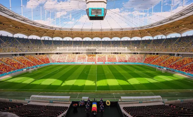 2026年4月8日周三，羅馬尼亞教練盧塞斯庫（Mircea Lucescu）的靈柩，在布加勒斯特（Bucharest）國家體育場（National Arena）由儀仗隊士兵護送，民眾從旁走過。(美聯社圖片/Andreea Alexandru) AP圖片
