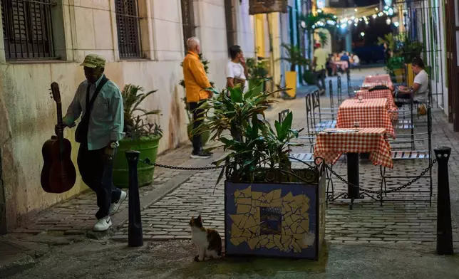 2026年4月15日，一名街頭音樂家走過哈瓦那（Havana）一間餐廳。(美聯社圖片/Ramon Espinosa) AP圖片