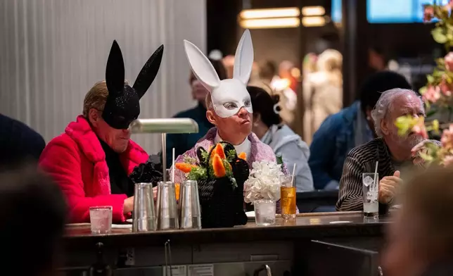 2026年4月5日周日，兩名戴著兔子面具的人在紐約的復活節帽飾巡遊期間於酒吧內飲酒。(美聯社圖片/Adam Gray) AP圖片