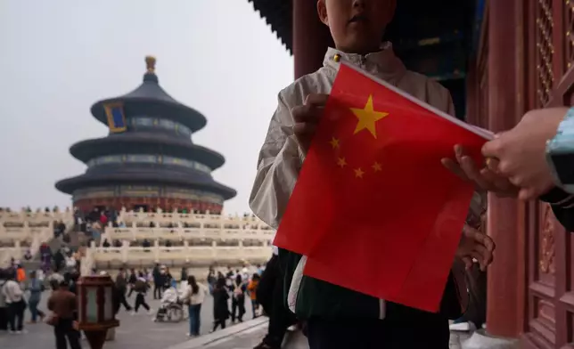 2026年4月3日周五，一名兒童在北京天壇祈年殿附近手持中國國旗。(美聯社圖片/Vincent Thian) AP圖片