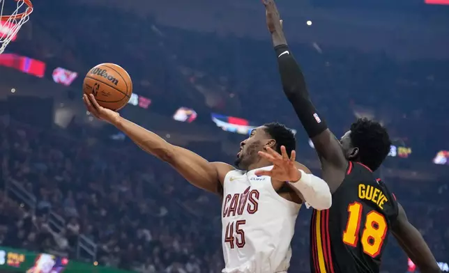 克里夫蘭騎士隊後衛當路雲米曹（45號）在周三（2026年4月8日）於克里夫蘭舉行的一場NBA籃球賽上半場，在阿特蘭大鷹隊前鋒穆罕默德古耶（18號）面前投籃。(美聯社圖片/Sue Ogrocki) AP圖片