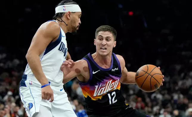 2026年4月8日周三，NBA籃球賽上半場，鳳凰城太陽隊後衛哥連吉利斯比（12號）運球，對陣達拉斯獨行俠隊後衛賴恩尼姆哈特（9號）。 (美聯社圖片/Ross D. Franklin) AP圖片