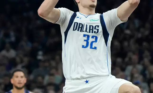 2026年4月8日周三，NBA籃球賽上半場，達拉斯獨行俠隊前鋒古柏弗拉格（32號）運球上籃得分，鳳凰城太陽隊後衛迪雲布加（1號）在旁觀看。 (美聯社圖片/Ross D. Franklin) AP圖片