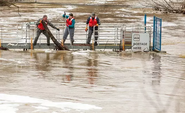 2026年4月15日周三，密歇根州特拉弗斯城（Traverse City）市中心，一群市政工人正在清理博德曼河堰（Boardman River Weir）上的雜物，這些雜物阻礙了氾濫的博德曼/奧塔韋河（Boardman/Ottaway River）水流。(美聯社圖片/Jan-Michael Stump/Traverse City Record-Eagle) AP圖片