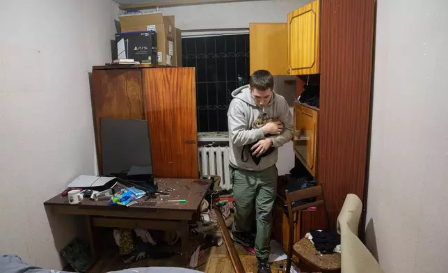 一名男子在烏克蘭基輔一個住宅區遭俄軍襲擊後損毀的房屋內抱著他的兔子，攝於2026年4月16日周四。(美聯社圖片/Evgeniy Maloletka) AP圖片