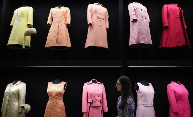 皇家收藏信託（Royal Collection Trust）一名職員望向伊利沙伯公主（Princess Elizabeth）曾穿著的日常服飾，該服飾在倫敦白金漢宮（Buckingham Palace）國王畫廊（King's Gallery）舉行的「英女皇伊利沙伯二世：時尚人生」（Queen Elizabeth II: Her Life in Style）展覽上展出，以紀念已故英女皇誕辰一百周年。攝於2026年4月9日周四。(美聯社圖片/Kirsty Wigglesworth) AP圖片