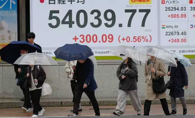4月2日，東京一間證券行內，人們走過顯示日本日經指數的電子股價板。AP圖片