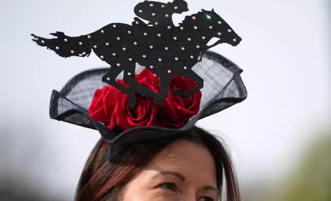 一名賽馬觀眾戴著以賽馬為主題的帽子，於2026年4月10日周五，抵達英格蘭利物浦（Liverpool）附近的艾恩特里賽馬場（Aintree racecourse），出席英國國家大賽馬節（Grand National Horse Racing festival）第二天的女士日（Ladies Day）活動。(美聯社圖片/Jon Super) AP圖片
