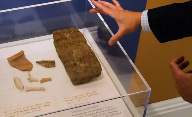 美國祖先協會（American Ancestors）博物館總裁兼行政總裁賴恩伍茲（Ryan J. Woods），於2026年4月15日周三，在波士頓的博物館內導覽「有色愛國者」（Patriots of Color）展覽期間，指向據信來自一名參與獨立戰爭的黑人士兵住所的文物。(美聯社圖片/Charles Krupa) AP圖片