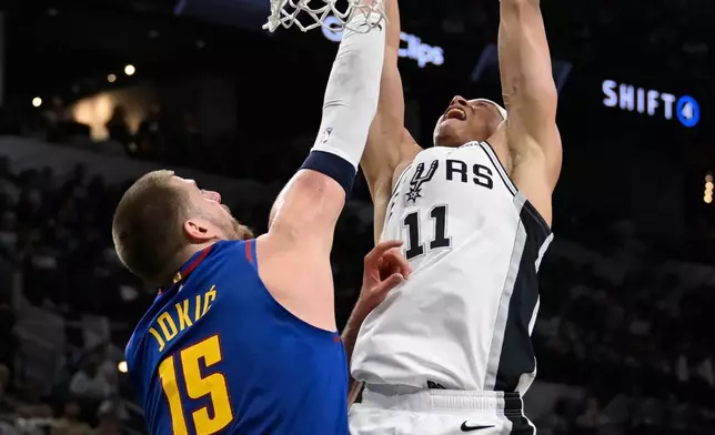 聖安東尼奧馬刺前鋒卡特·拜仁（Carter Bryant）（11號）在2026年4月12日周日於聖安東尼奧舉行的一場NBA籃球賽上半場，面對丹佛金塊中鋒尼古拉·祖傑（Nikola Jokic）入樽。(美聯社圖片/Darren Abate) AP圖片