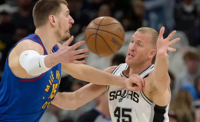 丹佛金塊中鋒尼古拉·祖傑（Nikola Jokic）（15號）在2026年4月12日周日於聖安東尼奧舉行的一場NBA籃球賽上半場，在聖安東尼奧馬刺中鋒美臣·普林利（Mason Plumlee）防守下傳球。(美聯社圖片/Darren Abate) AP圖片
