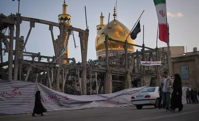 2026年4月4日周六，伊朗贊詹，行人走過大侯賽尼亞（Grand Hosseiniyeh）內一棟被摧毀的建築旁，背景可見清真寺。現場官員稱該建築於周二遭美國及以色列空襲擊中。（美聯社圖片/Francisco Seco） AP圖片