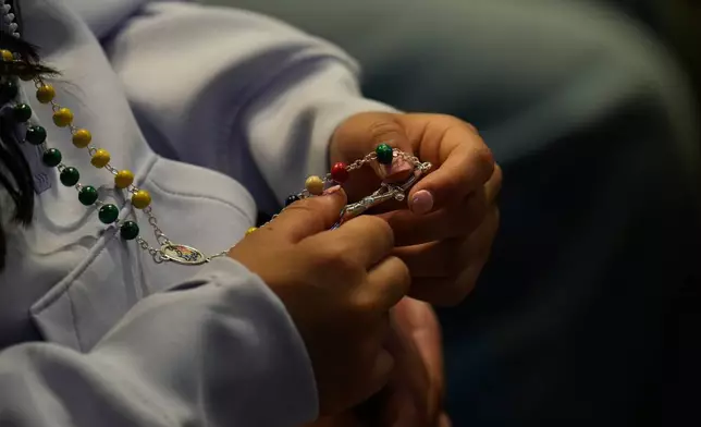 2026年4月11日周六，一名女子在梵蒂岡聖伯多祿大殿內，手持玫瑰經念珠出席由教宗利奧十四世帶領的和平守夜祈禱。（美聯社圖片/Gregorio Borgia） AP圖片