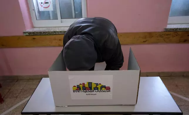 資料圖片：2022年3月26日，一名選民在約旦河西岸城市拉姆安拉的一個投票站準備選票。(美聯社圖片/Nasser Nasser, File) AP圖片