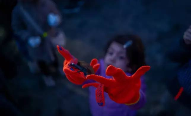 2026年4月4日周六，烏克蘭基輔，一名女孩在將獲救蝙蝠放歸野外的儀式上，放生一隻蝙蝠。(美聯社圖片/Dan Bashakov) AP圖片