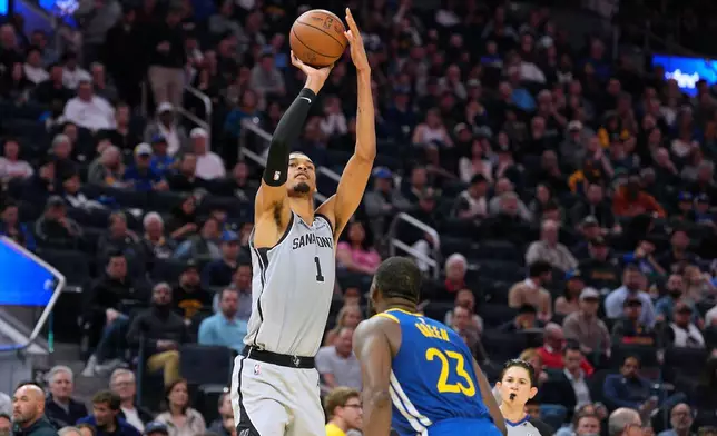 2026年4月1日周三，在三藩市舉行的一場NBA籃球賽上半場，聖安東尼奧馬刺前鋒維克托·雲班耶馬（1號）在金州勇士前鋒祖蒙特格連（Draymond Green）（23號）防守下投籃。(美聯社圖片/Tony Avelar) AP圖片