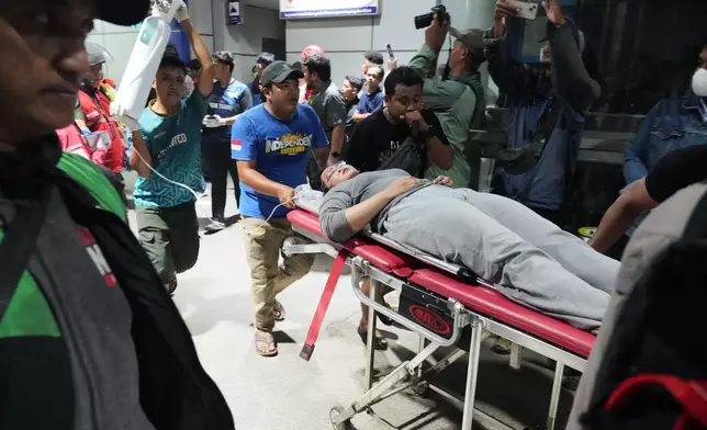周一（2026年4月27日），印尼勿加泗發生火車相撞事故後，民眾推着擔架上的女子。(美聯社圖片/Achmad Ibrahim) AP圖片